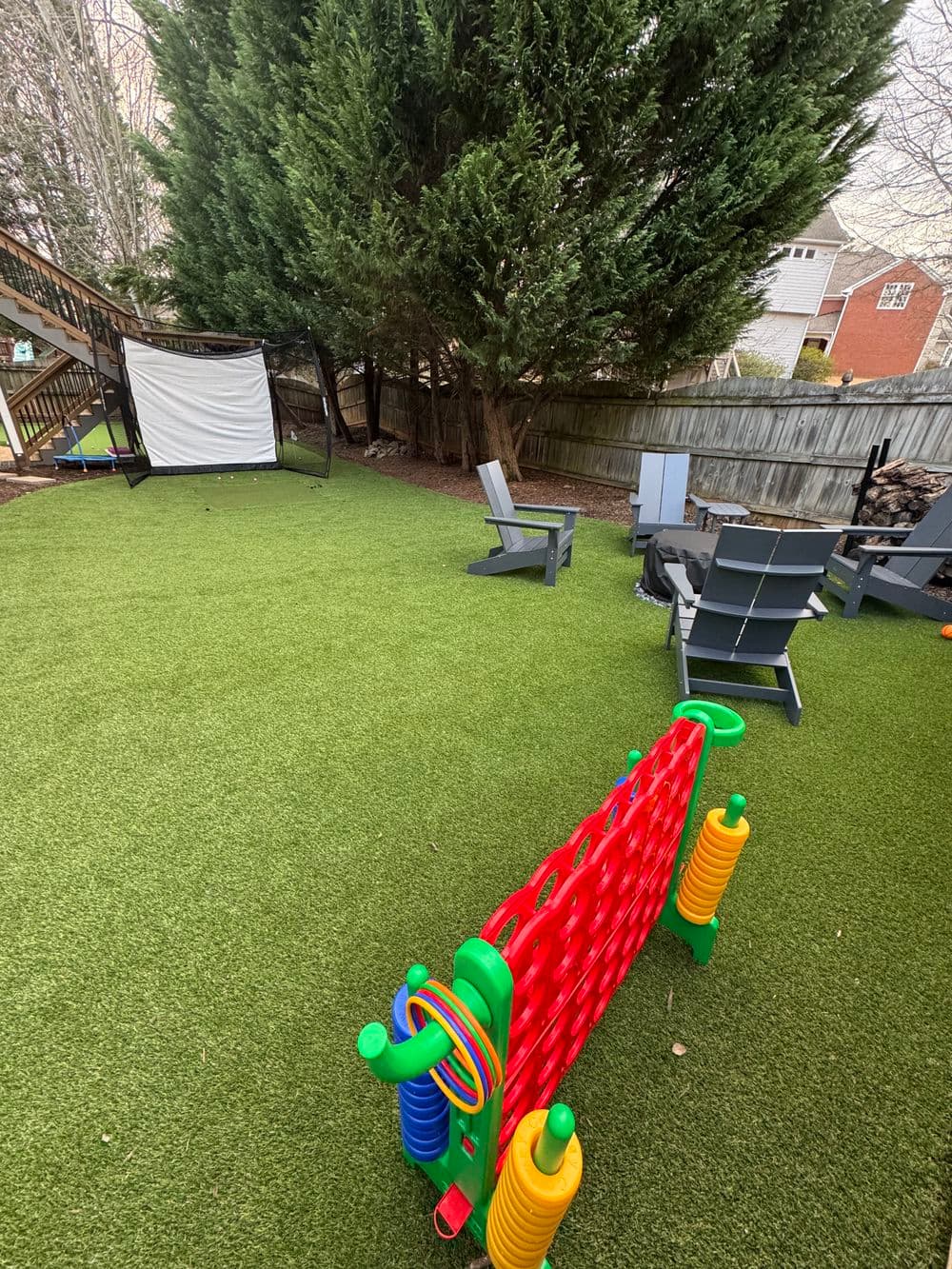 Colorful outdoor play area with artificial grass, lounge chairs, and a play structure.